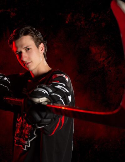 Male hockey player for a league holding a stick in an action pose for photo day by Frank Myrland Photogaphy