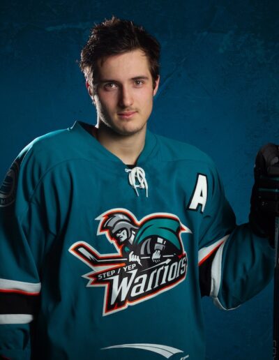 Male hockey player for a league holding a stick in an action pose for photo day by Frank Myrland Photogaphy