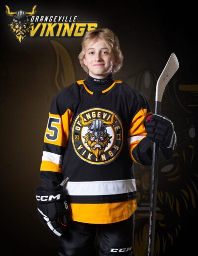 Male hockey player for a league holding a stick in an action pose for photo day by Frank Myrland Photogaphy