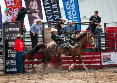 Action and sports photography of bucking broncos at the 2025 Headwaters Ram Rodeo at Orangeville Fairgrounds by Frank Myrland Photography