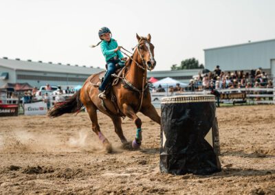 Action and sports photography of horse barrel riding at the 2025 Headwaters Ram Rodeo at Orangeville Fairgrounds by Frank Myrland Photography