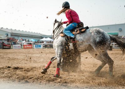 Action and sports photography of horse barrel riding at the 2025 Headwaters Ram Rodeo at Orangeville Fairgrounds by Frank Myrland Photography